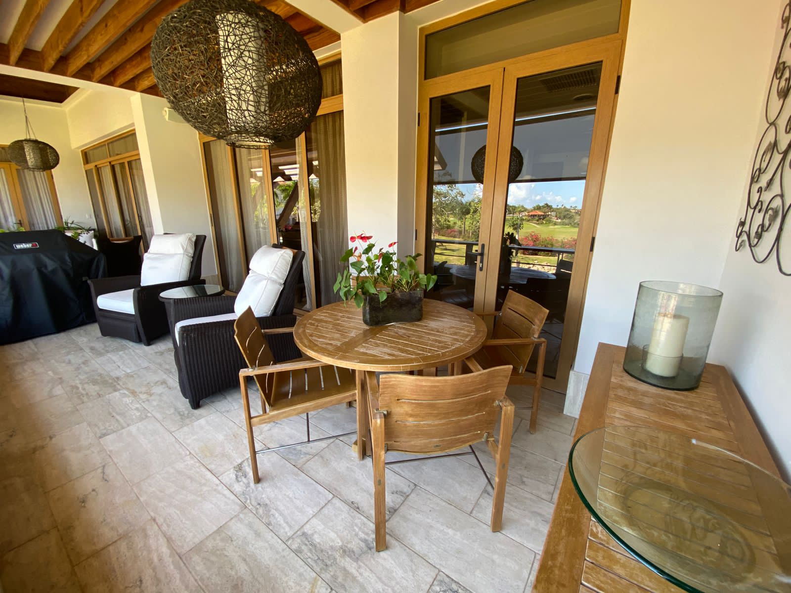 Covered terrace of the 3BR Los Altos Penthouse with dining table and lounge chairs, Casa de Campo