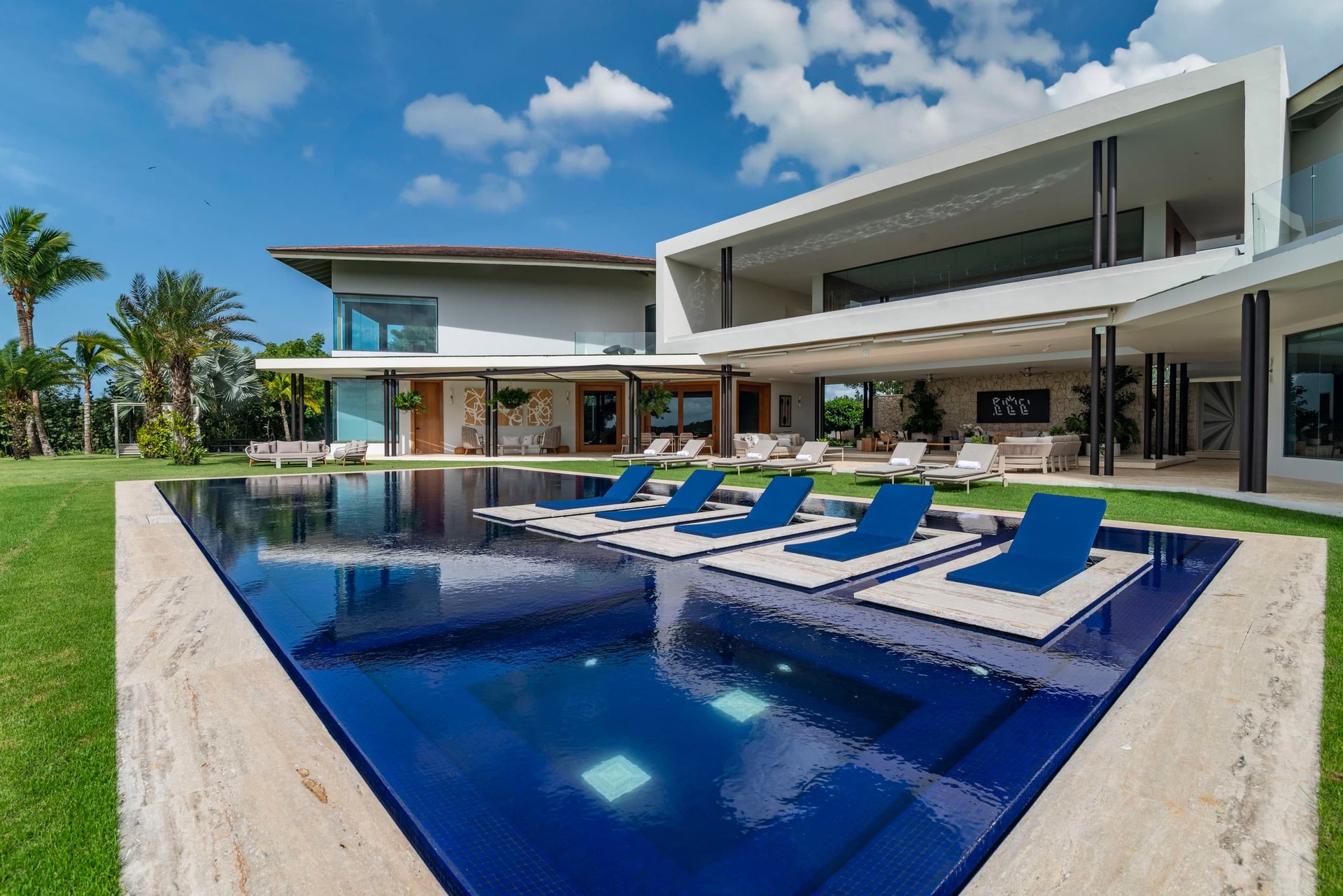 Cobalt mosaic infinity pool with sun loungers set in the water and the glass-fronted villa behind, Dye Fore Golf & Ocean Estate, Casa de Campo