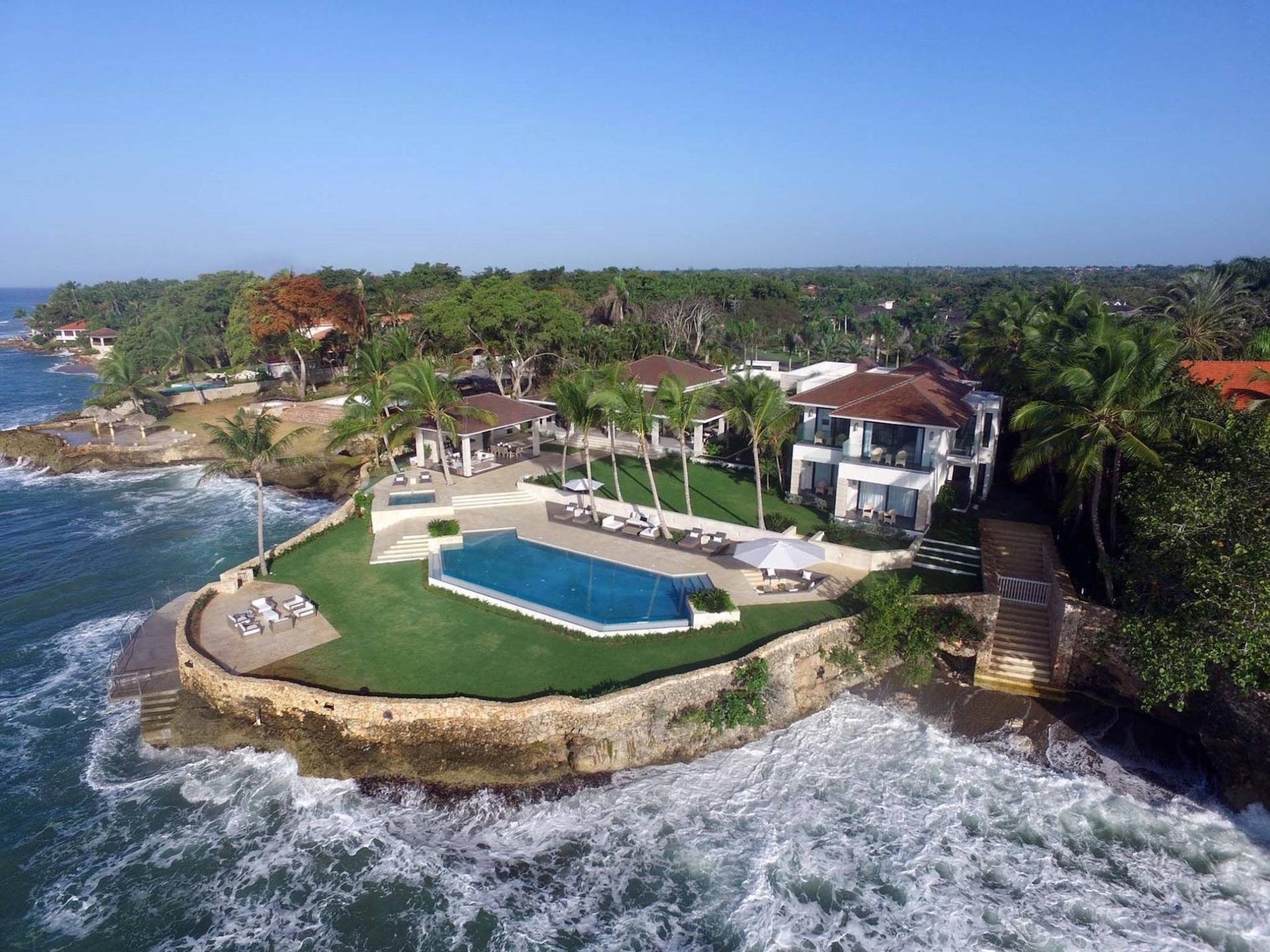 Aerial view of the villa on a rocky point, with lawn, infinity pool and pavilions surrounded by the sea, Punta Minitas Oceanfront Estate, Casa de Campo