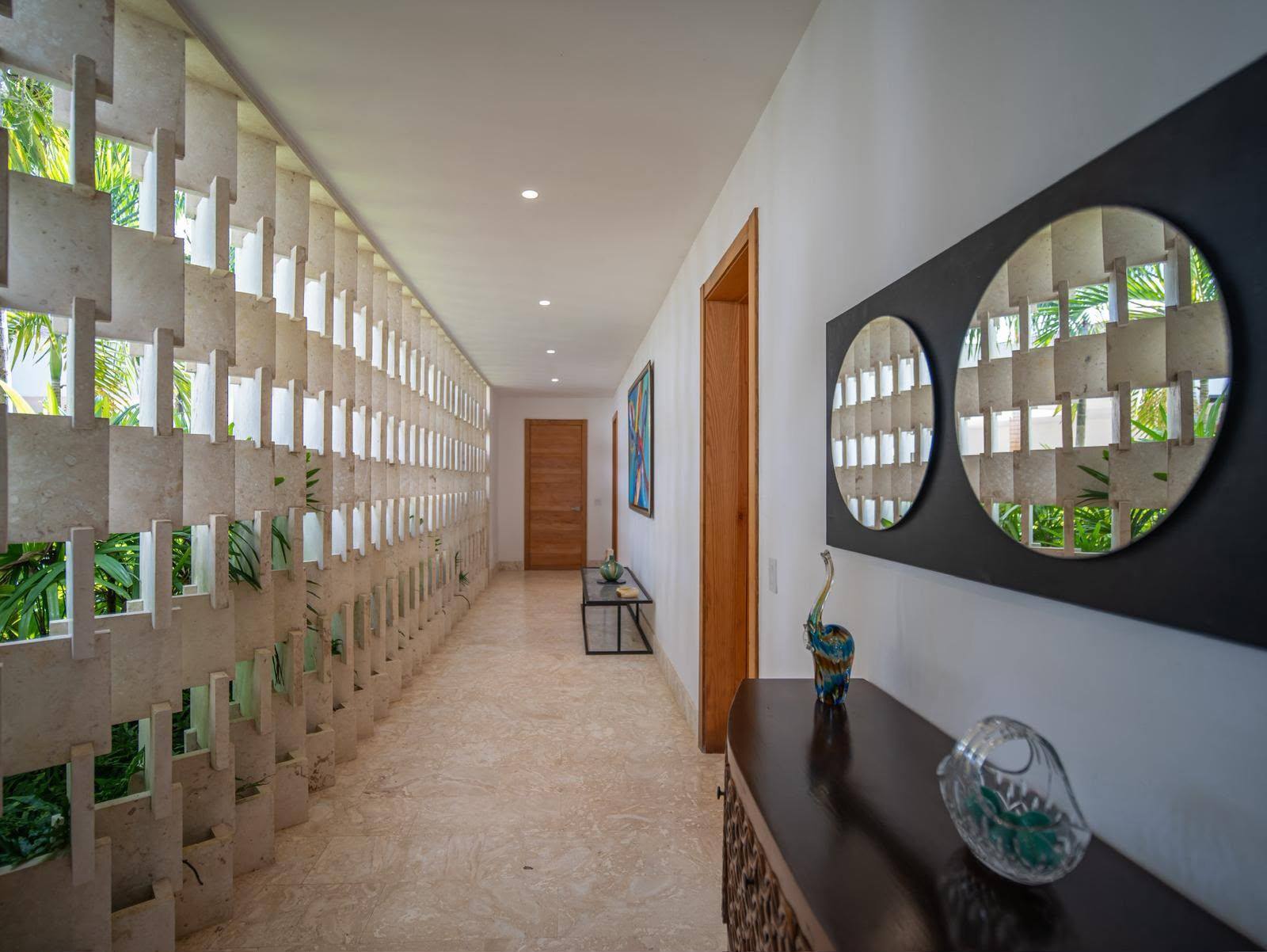 Breeze-block gallery hallway with round mirrors at Vista Lagos Private Estate