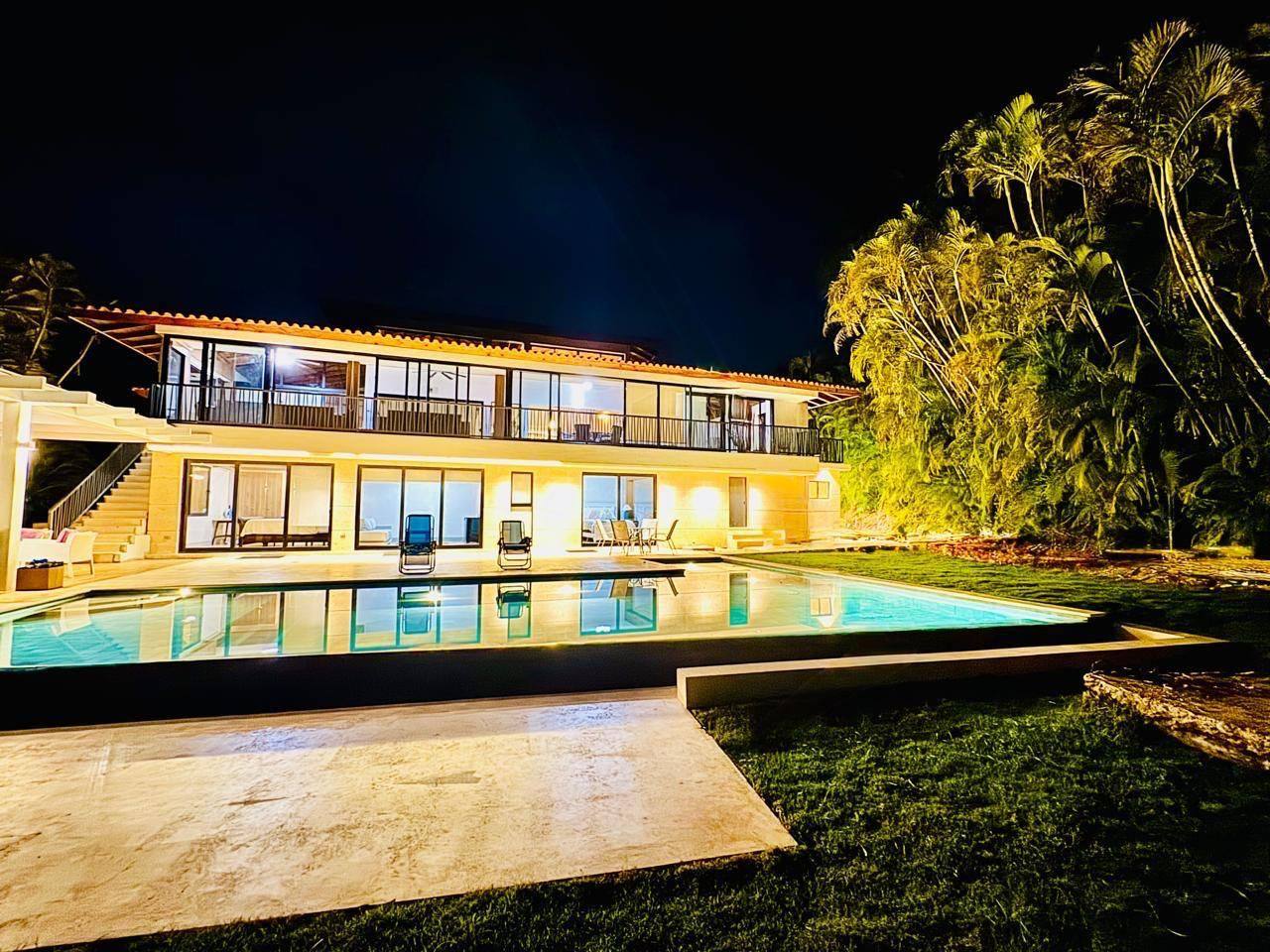 5BR Vivero Tropical Villa lit at night behind its pool